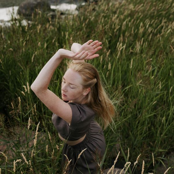 A serene person in a mindful movement pose, surrounded by calm nature.